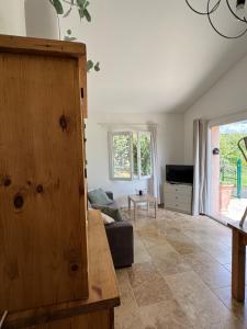 a living room with a couch and a tv at Maison de campagne in Quinson