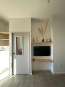 a living room with a flat screen tv on a wall at Chez Sam & Nico in Bollène