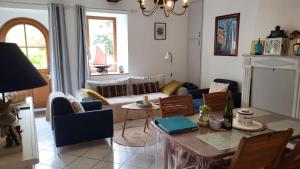 a living room with a table and a couch at 17th century house with swimming pool in Pleurtuit