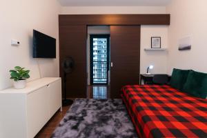 a bedroom with a bed and a desk with a tv at Suite Life Makati Vibes Views Relaxation 3870 in Manila