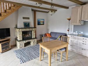 a living room with a table and a fireplace at Jūrena in Nida
