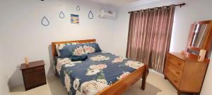 a bedroom with a bed with a blue comforter with flowers at Favored Haven in Sarava