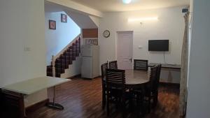 a dining room with a table and chairs and a television at Mystical Medows in Ooty