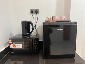 a coffee maker and a microwave next to each other at PEARL Suite Sungai Karang Balok in Kuantan