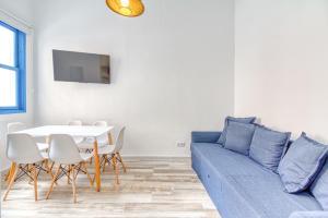 un salon avec un canapé bleu et une table dans l'établissement Joros 1- Estupendo apartamento a 5 min a pie de la playa, à Santa Cruz de la Palma