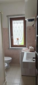 a bathroom with a window with a sink and a toilet at Casa al mare con vista sull asinara in Sorso