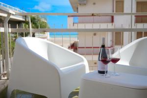 a bottle of wine and a glass on a balcony at siciliacasevacanze - Marina Domus 35 in Marina di Ragusa