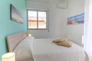 a bedroom with a white bed with a window at siciliacasevacanze - Marina Domus 35 in Marina di Ragusa