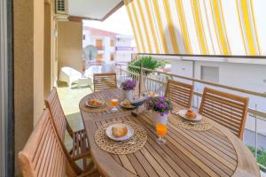 a wooden table with plates of food on a balcony at siciliacasevacanze - Marina Domus 35 in Marina di Ragusa