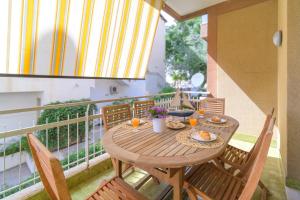 a wooden table and chairs on a balcony at siciliacasevacanze - Marina Domus 35 in Marina di Ragusa