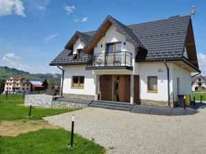 a white house with a black roof at Dychnijzese in Czarna Góra