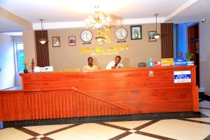 zwei Personen sitzen in einer Bar in einem Restaurant in der Unterkunft Hotel Next in Masaka