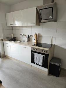 a kitchen with white cabinets and a stove top oven at Ferienwohnung Antes in Heppenheim an der Bergstrasse