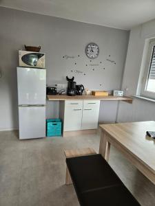 a kitchen with a white refrigerator and a clock on the wall at Ferienwohnung Antes in Heppenheim an der Bergstrasse +7 photos