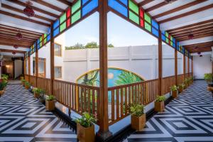 a hallway with stained glass windows and potted plants at La Moon Puducherry in Pondicherry