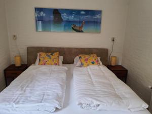 a bedroom with two beds and a painting on the wall at Holiday house Happy House - 2 km from the beach in Noordwijkerhout +38 photos