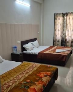 two beds in a hotel room with two beds at Vishwanath hotel in Uttarkāshi