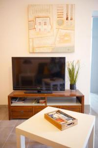 a living room with a tv and a coffee table at Maison 4 personnes tout confort à 300m de la plage - Clim & Wifi in Mimizan-Plage