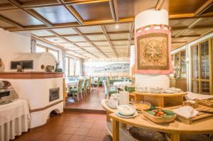 a restaurant with tables and chairs in a room at Waldpension Putz in Berg im Drautal
