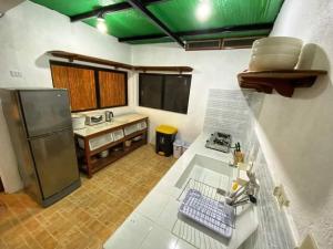 une cuisine avec un évier et un réfrigérateur dans l'établissement Villa Espera's Luxury Staycation, à Sampong 2 autres photos