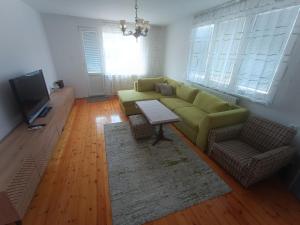 a living room with a green couch and a table at Fortress View Apartment in Belogradchik