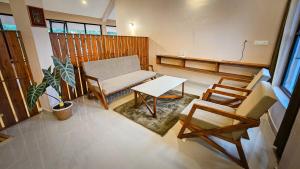 una sala de estar con un sofá, una mesa y sillas en A Hilltop Nature Retreat in Wayanad, en Tindummal