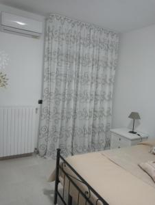 a bedroom with a bed and a curtain at Casa Vacanza Luna2 in Palagiano +20 photos