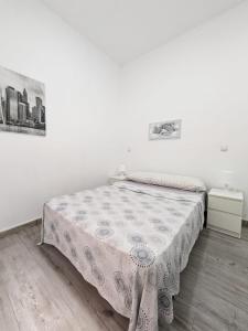 Cama en habitación blanca con mesa en Madrid Stay, en Madrid