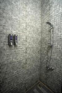 a shower in a bathroom with a tiled wall at Azad Siwa Hotel in Siwa
