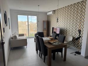 a living room with a dining room table and chairs at 3 Bedroom Flat at Naxxar in Talʼ Uai