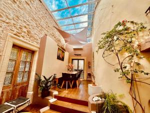 un salon avec un plafond en verre et une table dans l'établissement La maison du Bougainvillier 10 personnes, à Dions
