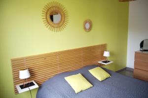 a bedroom with a bed with a mirror on the wall at Maison 4 personnes tout confort à 300m de la plage - Clim & Wifi in Mimizan-Plage