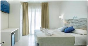 Ein Bett oder Betten in einem Zimmer der Unterkunft Mercury Beach Hotel