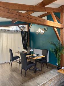 a dining room with a table and chairs and blue walls at Logis Hôtel Le Cygne in Le Bugue