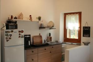 a kitchen with a refrigerator and a sink at Casa vacanza Mariangela in Stregna