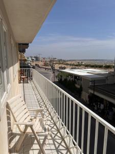 einen Balkon mit einem Stuhl und Stadtblick in der Unterkunft Appartamento 3 camere con vista mare - Agenzia Cocal in Caorle