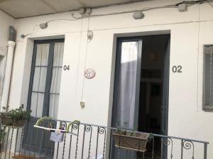 a white house with a door and a balcony at Aria di sale in Trapani