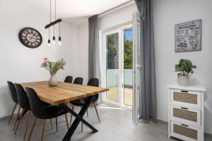 comedor con mesa de madera y sillas negras en Casa Philu in quiet area with amazing view, en Labin