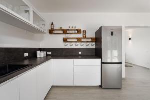 Una cocina con gabinetes blancos y un refrigerador de acero inoxidable. en Casa Philu in quiet area with amazing view, en Labin