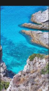a view of the blue water on a rocky shore at Il portale in Tropea