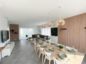 a dining room and living room with a table and chairs at Villa de standing en Champagne in Fresnes-lès-Reims