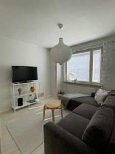 a living room with a couch and a tv at Harju Apartment in Jyväskylä
