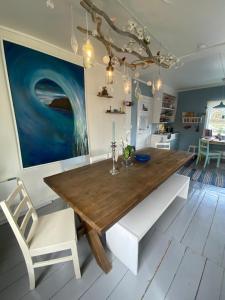 a dining room with a wooden table and white chairs at Hus i Kabelvåg sentrum in Kabelvåg