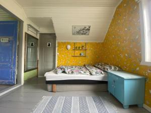 a bedroom with a bed and a yellow wall at Hus i Kabelvåg sentrum in Kabelvåg