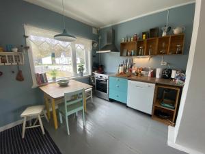 a kitchen with blue walls and a table and a table and a table at Hus i Kabelvåg sentrum in Kabelvåg