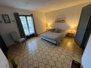 a bedroom with a bed and two lamps and a window at Charmante retraite champêtre in Bagnols-en-Forêt