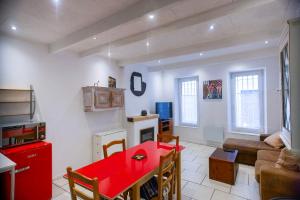 Proche du port et tout confort في لاسيوتا: غرفة معيشة مع طاولة حمراء وأريكة