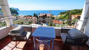 a balcony with a table and chairs and a view of the ocean at Medin Apartments BluVista in Petrovac na Moru