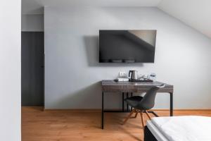 a desk in a room with a chair and a television at Koruna Hotel in Prague
