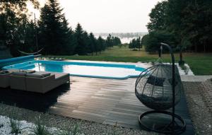 a swimming pool with a bench and a swing at THE VIEW - WILLA z basenem in Iława